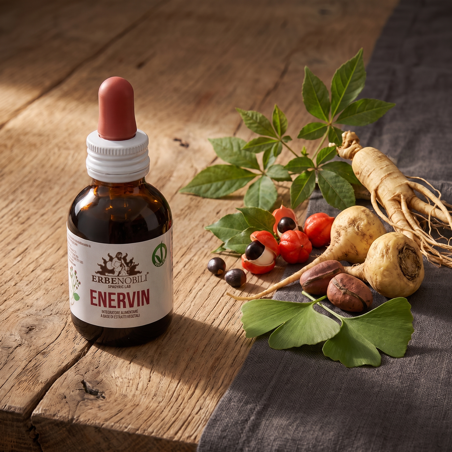 Ginseng, eleuterococco, guaranà e maca accanto al flacone Enervin